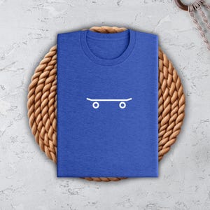a blue t - shirt with a skateboard drawn on it