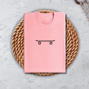 a pink shirt with a face drawn on it