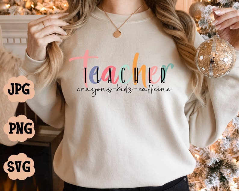 May include: A white sweatshirt with the text "Teacher crayons-kids-caffeine" in colourful letters.