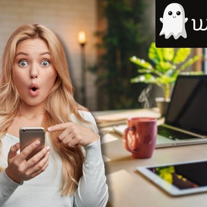 Könnte beinhalten: Eine Frau mit blonden Haaren sieht überrascht aus, während sie ein silbernes Smartphone hält. Sie zeigt mit ihrem rechten Zeigefinger auf das Telefon. Der Hintergrund ist verschwommen und zeigt einen Laptop, eine Tasse und ein Tablet.