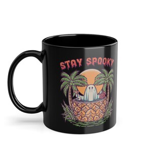 May include: Black coffee mug with a ghost in a pineapple, palm trees, and the text "Stay Spooky".