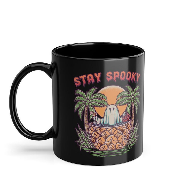 May include: Black coffee mug with a ghost in a pineapple, palm trees, and the text "Stay Spooky".