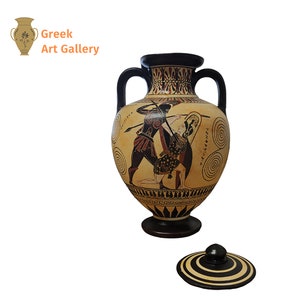 May include: A black and brown ceramic amphora with a lid. The amphora is decorated with a black figure painting of two warriors fighting. The amphora is on a white background.