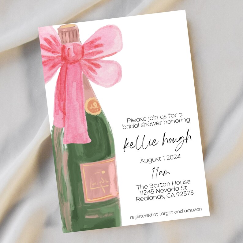 May include: A pink and green watercolor illustration of a champagne bottle with a pink bow. The text on the invitation reads "Please join us for a bridal shower honoring kellie hough August 1 2024 11am The Barton House 11245 Nevada St Redlands, CA 92373 registered at target and amazon"