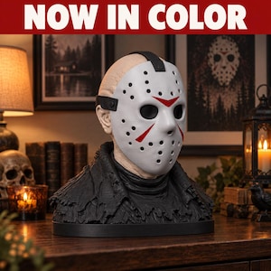Könnte beinhalten: Eine Büste einer kahlen Figur mit einer weißen Eishockeymaske, die rote dreieckige Markierungen über den Augen und dem Mund aufweist. Die Figur trägt ein strukturiertes, schwarzes Kleidungsstück um Hals und Schultern auf einem schwarzen Sockel. Text: NOW IN COLOR.