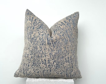May include: A blue and beige patterned throw pillow with a zipper closure.