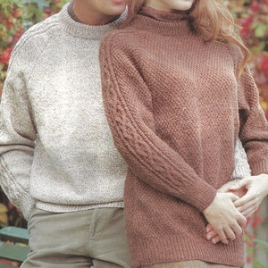 May include: Two knitted jumpers, one in a light beige colour with a speckled pattern and the other in a brown colour with a ribbed texture. Both jumpers have long sleeves and a crew neck.