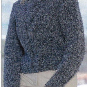 Könnte beinhalten: Ein blauer Strickpullover mit hohem Kragen und Zopfmuster.