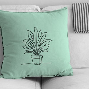 Pu&ograve; includere: Un cuscino verde chiaro con un disegno a linea nera di una pianta in vaso. La pianta ha foglie lunghe e strette.