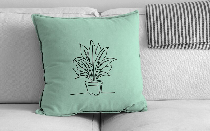 Pu&ograve; includere: Un cuscino verde chiaro con un disegno a linea nera di una pianta in vaso. La pianta ha foglie lunghe e strette.