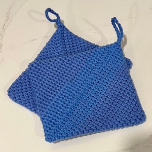 May include: Two blue knitted pot holders with loops. The pot holders are made of a soft, textured yarn.