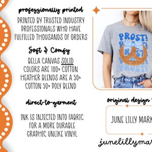 May include: A heather gray t-shirt with a pretzel graphic and the word "PROST!" in blue. The design includes a blue and white bow. The shirt is a Bella Canvas blend.