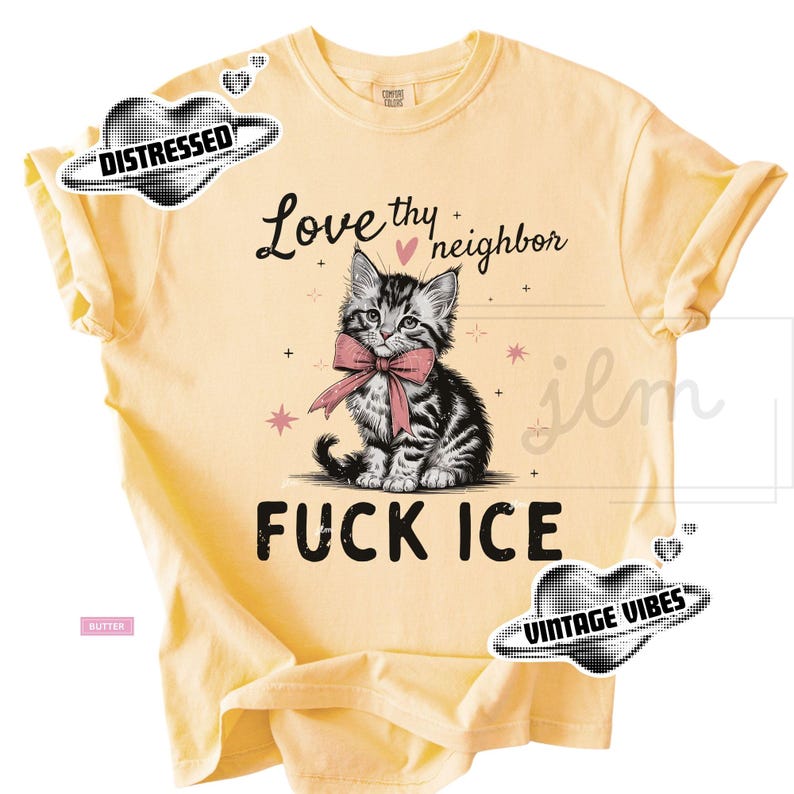 May include: Butter-colored t-shirt featuring a graphic of a kitten wearing a pink bow tie. The text "Love thy neighbor" and "FUCK ICE" are above and below the kitten illustration. The shirt has rolled-up sleeves.