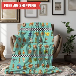 May include: A teal throw blanket featuring a repeating pattern of whimsical cartoon creatures. The blanket has a black and white checkered border and is draped over a chair. The blanket is made of a soft material.