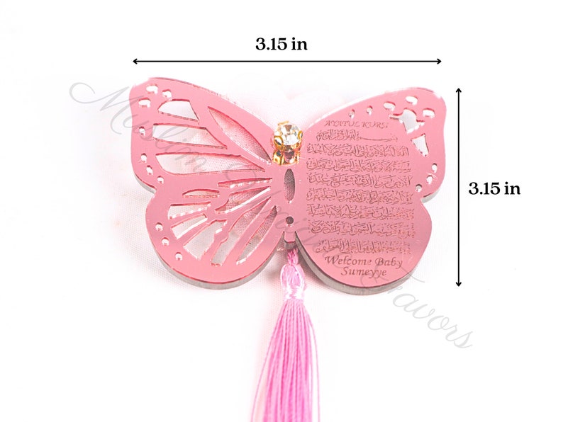 K&ouml;nnte beinhalten: Rosa Schmetterlingsf&ouml;rmiger Acryl-Anh&auml;nger mit einem rosa Quasten. Der Anh&auml;nger hat ein dekoratives Design und den Text "Welcome Baby Sumeyye". Der Anh&auml;nger misst 8 cm in der Breite und H&ouml;he.