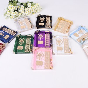 Op de afbeelding: Assortiment van gebedsets in verschillende kleuren, elke set bevat een gebedskleed, een bladwijzer en gebedskralen. De gebedskleden zijn gemaakt van fluweel en hebben ingewikkelde ontwerpen. De sets zijn verpakt in doorzichtige plastic dozen.