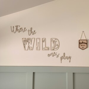 May include: Wooden wall decor with the words "Where the Wild Ones Play" and a sign that says "Hakuna Matata".