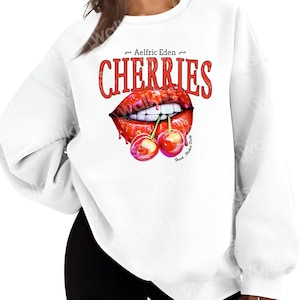 May include: White sweatshirt with a red graphic of a pair of lips biting a cherry stem with two cherries on it. The text "~ Aelfric Eden ~ CHERRIES" is printed above the graphic.