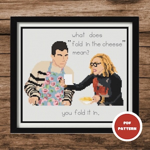 May include: Cross stitch pattern featuring a cartoon image of two people, a man and a woman, with the text "what does "fold in the cheese" mean? you fold it in."  The pattern is in black and white with a red and white "PDF PATTERN" label in the bottom right corner.