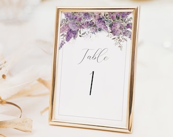 May include: A gold-framed table number card with a purple floral design and the text "Table 1".