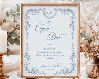 Może przedstawiać: Oprawiony znak z napisem "Open Bar" w eleganckim skrypcie, otoczony niebieskimi kwiatowymi akcentami. Znak zawiera podziękowanie i imiona, idealne na wesele lub imprezę.