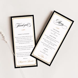 May include: Elegant wedding stationery set featuring a "Thank You" card and a menu card. Both cards have a black border with gold accents and elegant script. The menu lists courses like Beef Tenderloin and Rosemary Chicken.