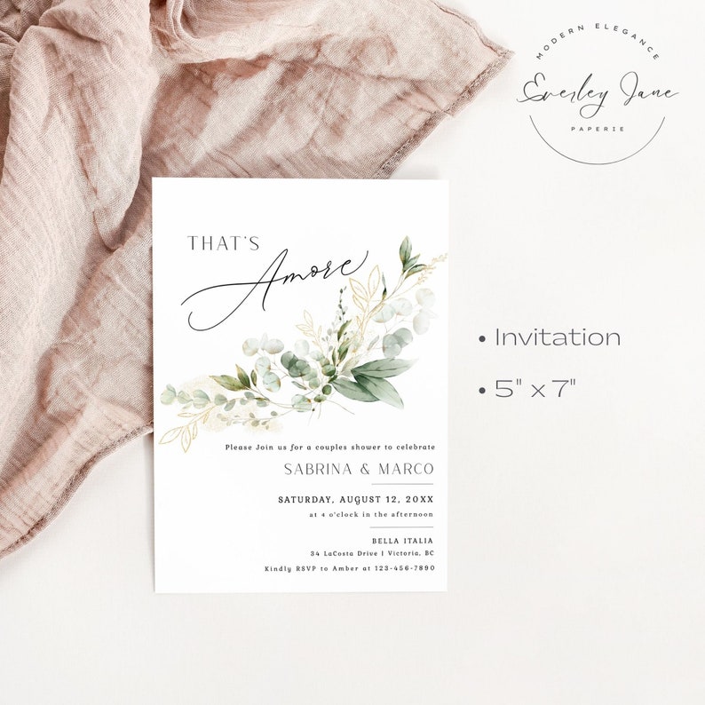 Peut inclure: Une carte d'invitation blanche avec des illustrations florales vertes et dor&eacute;es. Le texte indique "That's Amore" et comprend les d&eacute;tails d'une f&ecirc;te de mariage pour c&eacute;l&eacute;brer Sabrina & Marco. L'invitation mesure 5 pouces par 7 pouces.