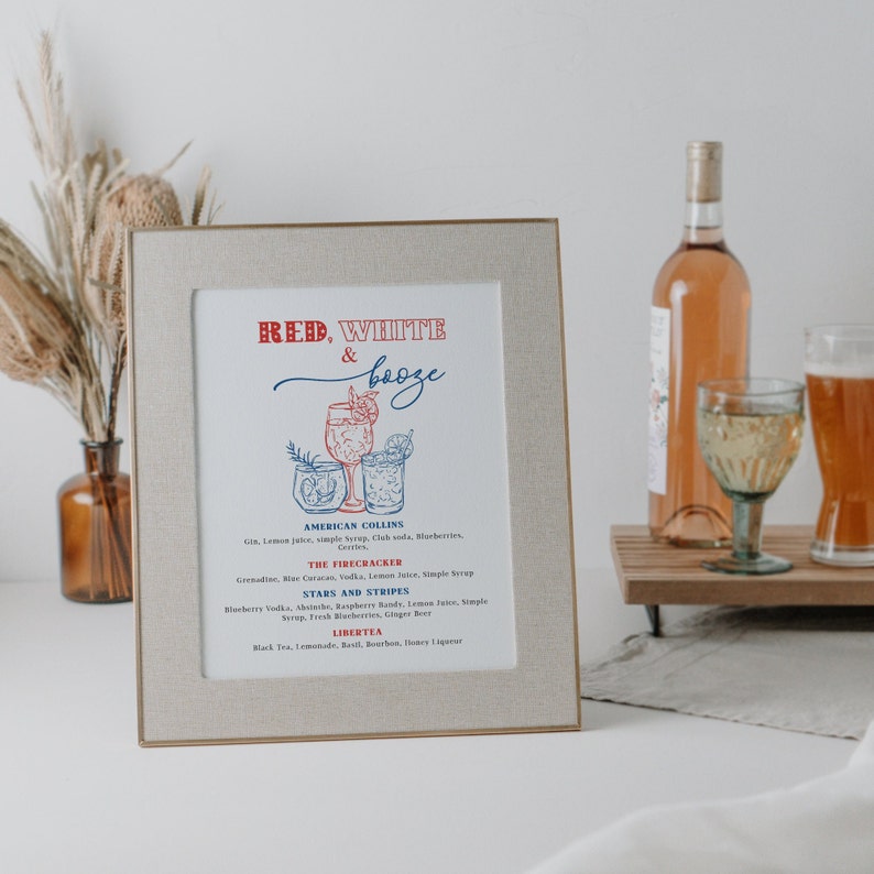 May include: A framed print with a red, white, and blue color scheme. The print features a list of cocktails with names like "American Collins", "The Firecracker", "Stars and Stripes", and "Libertea".