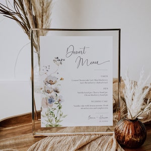 Könnte beinhalten: Eine gerahmte Dessertkarte mit einem Aquarell-Blumenmuster. Die Karte listet Torten, Kuchen und eine Hochzeitstorte auf. Der Text lautet "Dessert Menu", "Torten", "Zitronen-Cheesecake-Torte. Mini-Blaubeertorte. Erdbeer-Rhabarber-Torte", "Kuchen", "Nutella-Handkuchen. Kirsch-Handkuchen. Zitrus-Blaubeer-Handkuchen", "Hochzeitstorte", "Vanillekuchen mit Zitronenmousse, frischen Erdbeeren und Himbeeren", "Bianca + Harrison", "06.12.2024".