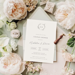 May include: A white wedding invitation with a floral wreath and the initials "N.K." at the top. The invitation is for a couples shower honoring Natalie & Kevin. The date is Saturday, August 26, 2024, at 4 o'clock. The location is Starling Estates Vineyard, 563 Lakeshore Drive, Kelowna, BC. RSVP to Jenna at 123-456-7000. Registered at Crate and Barrel and West Elm.