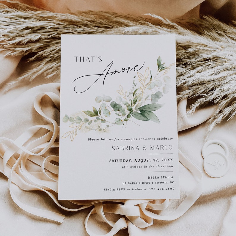 Peut inclure: Une carte d'invitation blanche avec une illustration aquarelle de feuilles vertes et dor&eacute;es. Le texte sur la carte indique "That's Amore" et comprend les d&eacute;tails d'une f&ecirc;te de mariage pour c&eacute;l&eacute;brer Sabrina & Marco le 12 ao&ucirc;t 20XX &agrave; 16h00 &agrave; Bella Italia, 34 LaCosta Drive, Victoria, BC. Veuillez confirmer votre pr&eacute;sence aupr&egrave;s d'Amber au 123-456-7890.
