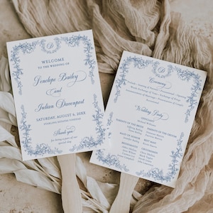 May include: Two wedding fan programs with blue floral border designs. The fans have text that reads "Welcome to the Wedding of Penelope Bailey and Julian Davenport" and "Ceremony". The fans are on a neutral background.