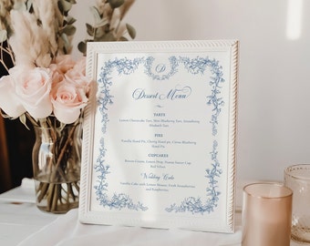 Może przedstawiać: Białe menu deserów w ramie z niebieskimi kwiatowymi akcentami i niebieskim pismem kursywą. Menu zawiera tartaletki, ciasta, babeczki i tort weselny. Tekst brzmi: "Dessert Menu", "Tartaletki", "Tarte z serkiem limonkowym, mini tartaletki z borówkami, truskawka", "Tarte z rabarbarem", "Ciasta", "Ciasto z Nutellą, ciasto wiśniowe, ciasto cytrusowe z borówkami", "Ciasto ręczne", "Babeczki", "Krem cytrynowy, cytrynowy kropek, czapka z masłem orzechowym", "Czerwony aksamit", "Tort weselny", "Tort waniliowy z musem cytrynowym, świeżymi truskawkami i malinami."