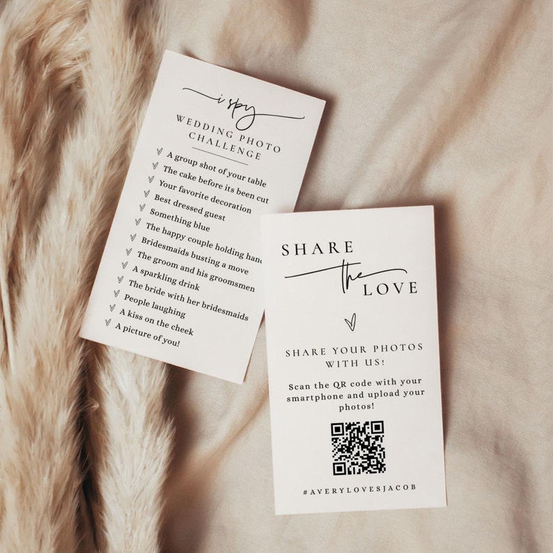 May include: Two white cards with black text. The first card has a checklist titled "I Spy Wedding Photo Challenge" with a list of items to find in wedding photos. The second card has the text "Share the Love" and a QR code with the text "Share your photos with us! Scan the QR code with your smartphone and upload your photos! #AveryLovesJacob".