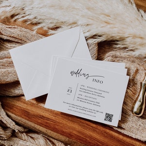 May include: A white wedding invitation card with black text. The card includes the wedding date, August 23rd, and the wedding ceremony and reception times and locations. A QR code is included for more information.