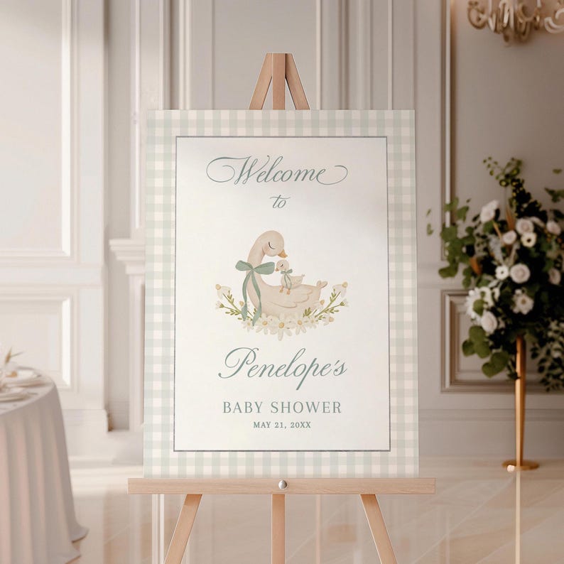 May include: Welcome to Penelope's Baby Shower sign with a light blue and white gingham background. A watercolor illustration of two ducks, one with a blue ribbon, is in the center. The text reads "Welcome to Penelope's Baby Shower May 21, 20XX".