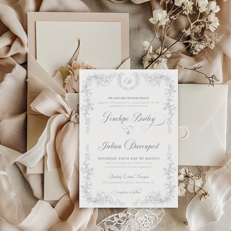 Op de afbeelding: Elegante trouwuitnodigingssuite met een bloemenrandontwerp. De uitnodigingskaart bevat de namen Penelope Bailey en Julian Davenport, met de datum en tijd van de ceremonie. De suite bevat een envelop, een kaart en een lint.