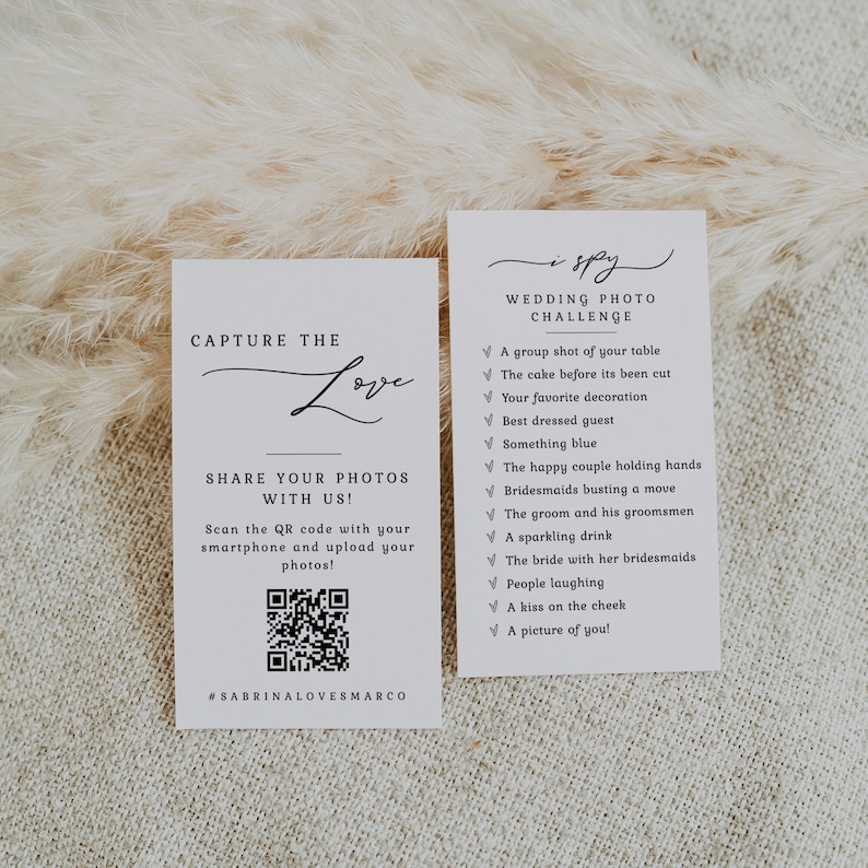 May include: Two white cards with black text. The card on the left says "Capture the Love" with a decorative script font and a QR code. The card on the right says "Wedding Photo Challenge" and lists a series of photo prompts.