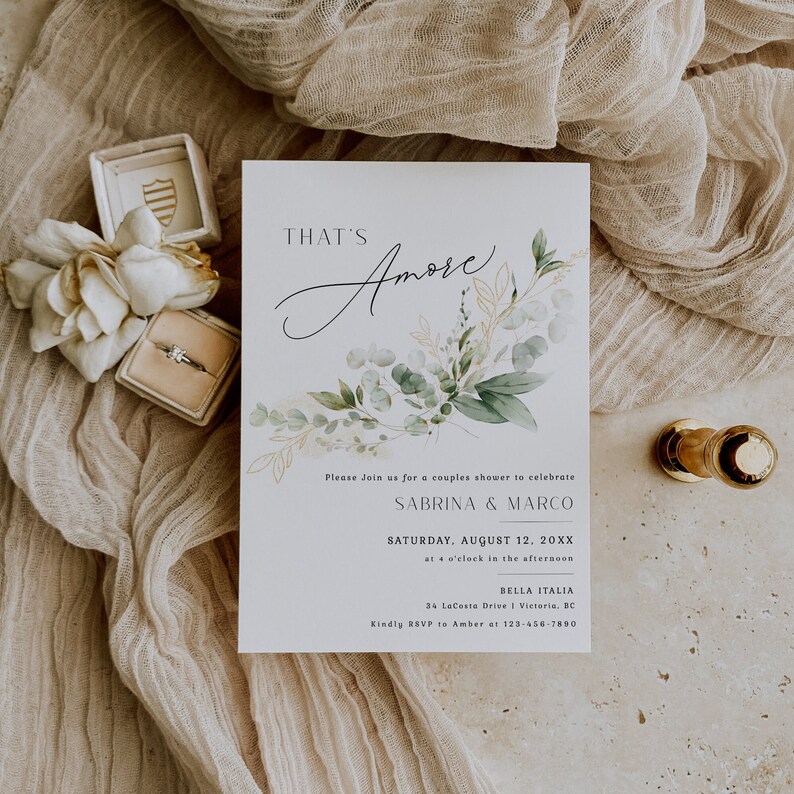 Peut inclure: Une carte d'invitation blanche avec des illustrations florales vertes et dor&eacute;es. Le texte indique "That's Amore" en &eacute;criture cursive. L'invitation est pour une f&ecirc;te de fian&ccedil;ailles pour c&eacute;l&eacute;brer Sabrina & Marco le samedi 12 ao&ucirc;t 20XX &agrave; 16 heures &agrave; Bella Italia, 34 Lacoste Drive 1 Victoria, BC. Veuillez confirmer votre pr&eacute;sence aupr&egrave;s d'Amber au 123-456-7890.