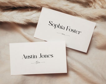 Può includere: Due carte bianche con testo nero. La carta superiore dice "Sophia Foster" con la parola "one" scritta in corsivo sotto. La carta inferiore dice "Austin Jones" con la parola "two" scritta in corsivo sotto.