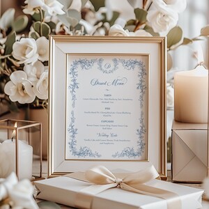 Puede incluir: Un men&uacute; de postres enmarcado con un borde floral azul. El men&uacute; incluye tartas, pasteles, cupcakes y un pastel de boda. El texto est&aacute; en una fuente cursiva.