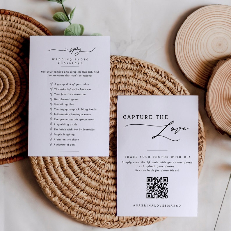 May include: A white card with a wedding photo challenge checklist. The checklist includes items like "a group shot of your table", "the cake before it's been cut", and "something blue". The card also has a QR code and the text "Capture the Love" and "#SabrinaLovesMarco".