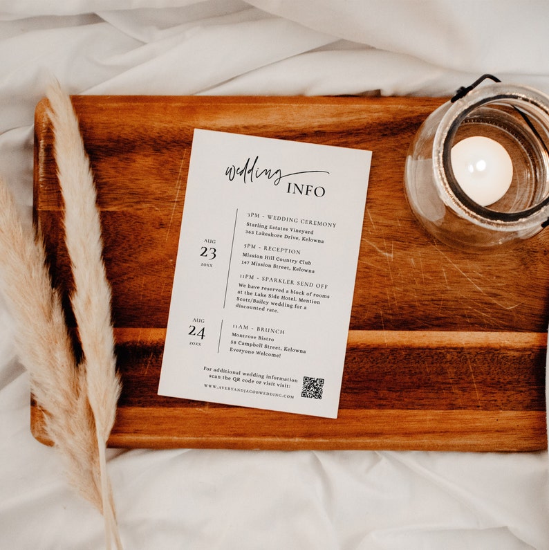 May include: A white card with black text listing wedding ceremony and reception details for August 23rd and 24th. The text includes the time, location, and a note about a sparkler send off. A QR code is included at the bottom of the card.