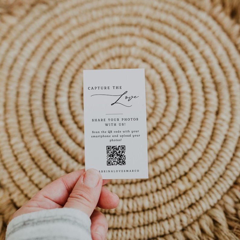 May include: White card with black text that reads "Capture the Love" and "Share your photos with us!" with a QR code and the text "ABRINALOVESMARCO" at the bottom.