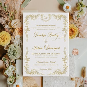 Può includere: Un invito di nozze bianco con un bordo floreale dorato e calligrafia. L'invito annuncia il matrimonio di Penelope Bailey e Julian Davenport sabato 6 agosto 2024 alle 16:00 presso Starling Estates Vineyard, 363 Lakeshore Drive, Kelowna, BC. Ricevimento a seguire.