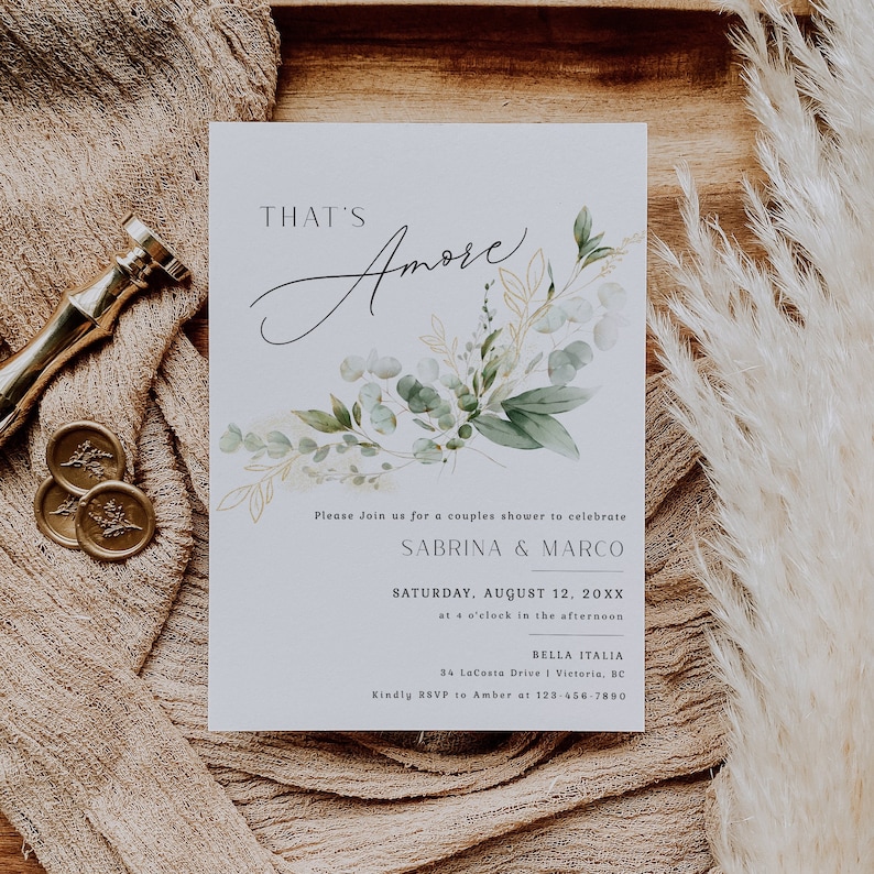 Peut inclure: Une carte d'invitation blanche avec des illustrations florales vertes et dor&eacute;es. Le texte indique "That's Amore" et comprend des d&eacute;tails pour une f&ecirc;te de mariage pour c&eacute;l&eacute;brer Sabrina & Marco. L'&eacute;v&eacute;nement est pr&eacute;vu pour le samedi 12 ao&ucirc;t 20XX &agrave; 16h00 &agrave; Bella Italia, 34 LaCosta Drive | Victoria, BC. Veuillez confirmer votre pr&eacute;sence aupr&egrave;s d'Amber au 123-456-7890.
