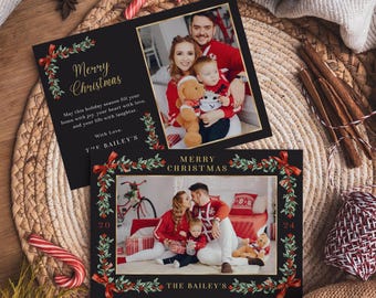 May include: A black Christmas card with a gold border and a red and green holly wreath design. The card features a family photo of a couple and their child in front of a Christmas tree. The text on the card reads "Merry Christmas" and "The Bailey's".