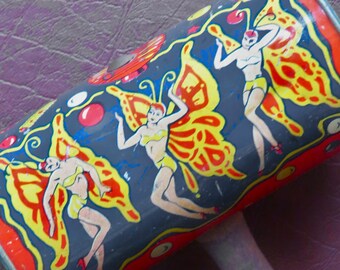 May include: A red, yellow and blue toy noisemaker with a wooden handle. The noisemaker is decorated with images of women wearing butterfly wings.