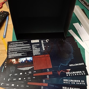 May include: A black box set titled "Hellraiser: The Ultimate 4K Collection" with multiple Blu-ray cases featuring the Hellraiser movie titles. The box set has a graphic of a puzzle box and chains.