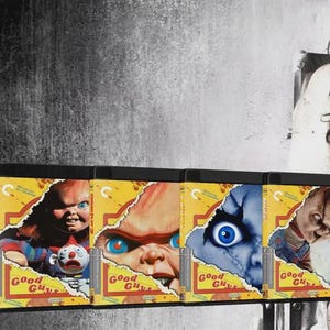 Puede incluir: Una colección de seis cajas de Blu-ray de la serie de películas Child's Play. Cada portada amarilla muestra el logotipo de Good Guys y gráficos de papel rasgado que revelan diferentes primeros planos del muñeco Chucky con ojos azules y pelo rojo.